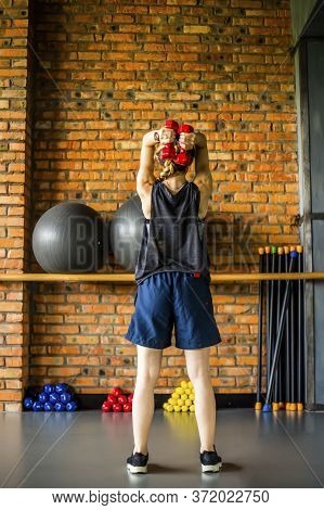 Young girl is doing fitness and different exercises in the gym.
Sport is health. Many sports equipme