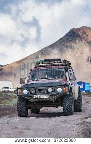 Japanese Sport Utility Vehicle Nissan Patrol Driving On Mountain Road On Background Volcano Landscap