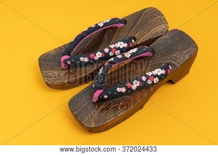 Japanese Traditional Geta Sandal On Yellow Floor. Traditional Japanese Asian Wood Footwear Called Ge