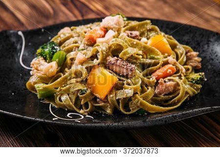 Closeup On Spinach Fettuccine Pasta With Beef And Vegetables On The Wooden Table, Horizontal