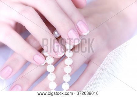 Female Hand With French Manicure On A White Background.