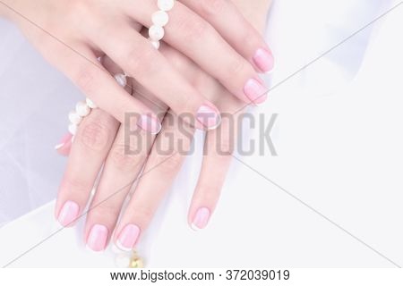 Female Hand With French Manicure On A White Background.