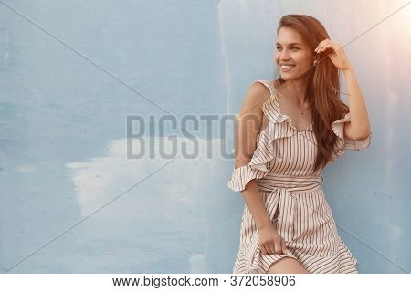 Portrait Of A Young Smiling Woman Near Blue Wall Outdoor