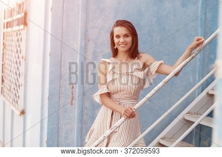 Portrait Of A Young Smiling Woman Near Blue Wall Outdoor