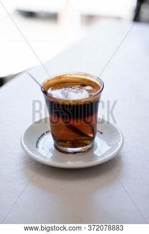 Coffee With Three Colors, Brown Black And Yellow With A Spoon
