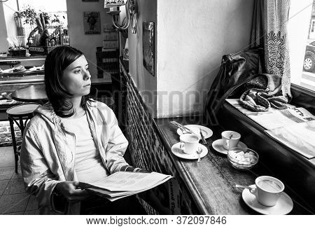 St. Petersburg, Russia - August 15, 2011:  A Girl Sitting In A French Cafe With Morning Coffee And A