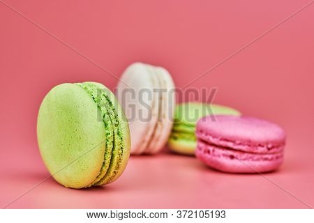 Macaroons On Pink Background. Colorful Small Cookie From Ground Almonds And Coconut. Popular Confect