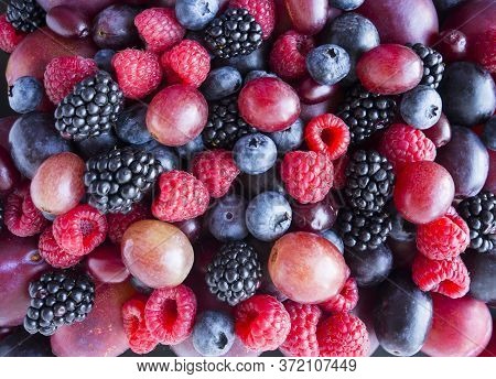 Background Of Fresh Vegetables And Fruits. Ripe Blackberries, Blueberries, Plums, Pink Grapes, Raspb