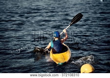 A Guy Wearing A Helmet On A Canoe Polo Rowing A Paddle And Sailing On Water. Canupolo. Puts On A Res