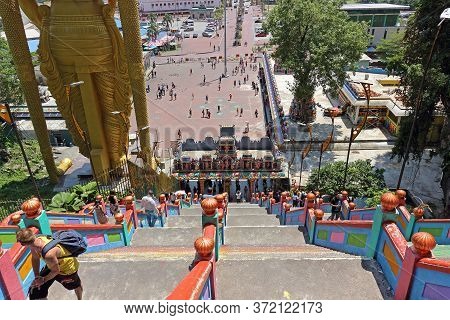 Kuala Lumpur, Malaysia - March 15, 2019: Long Colorful Staircase Down From Batu Caves. People Go Dow