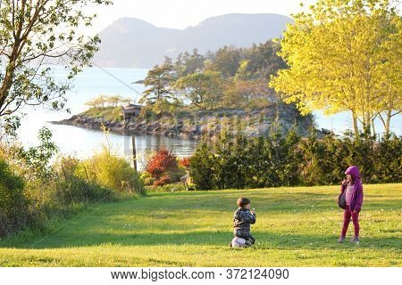 Vancouver Island British Columbia Canada, June 7, 2020: A child playing outside with a soccer ball o