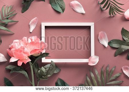 Creative Flat Lay, Top View With Light Coral Peony, Petals And Exotic Palm Leaves Around White Empty