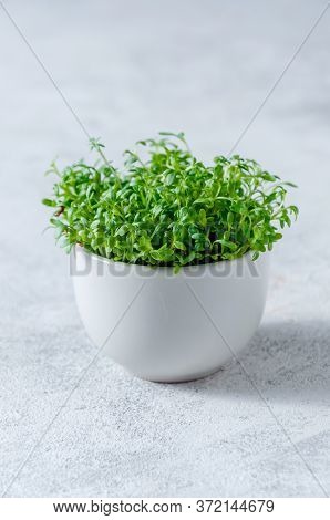 Close Up Watercress Microgreens In Little White Bowl On Light Background