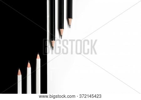 Composition With Black Pencils On A White Background And White Pencils On A Black Background Lying N