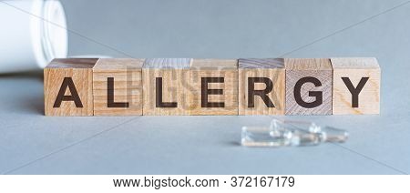 Allergy Text On Wooden Blocks. In Front Of A Row Of Cubes Are Ampoules, In The Background - White Pl