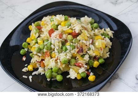 Rice With Vegetables In A Black Plate