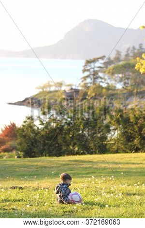 Vancouver Island British Columbia Canada, June 7, 2020: A Child Playing Outside With A Soccer Ball O