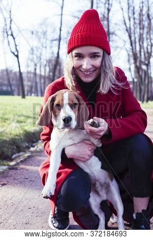 Pretty Young Girl In Redd Coat Playing With Dog Outside In Green Park, Lifestyle People Concept