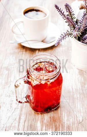 Tisane Or Red Herbal Tea In A Transparent Glass Jar On A Table Outdoors In A Tea House In The Street