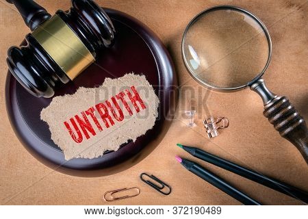 Untruth. Law, Regulations And Judgment Concept. Judges Hammer, Stationery And Magnifying Glass