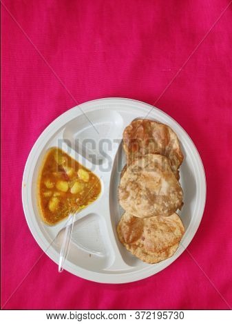 Puri And Potato Curry Aalu Sabji - An Indian Cuisine In Round Plate.