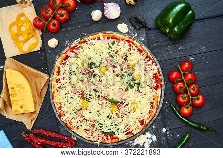 Raw Pizza With Mozzarella Cheese, Meat, Tomatoes, Mushrooms, Peppers, Herbs On A Dark Wooden Backgro