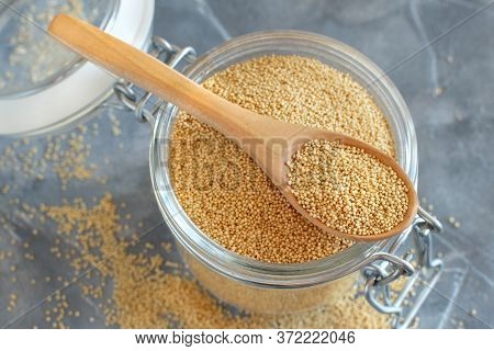 Glass Jar Of Raw Amaranth Grain With A Spoon Close Up