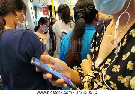 Bangkok, Thailand - March 14, 2020 : Asian Passengers In Sky Train Public Transport Wearing Hygiene 