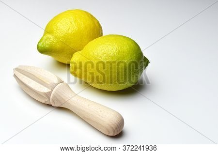 Lemon Citrus Fruits With Wooden Hand Squeezer On White Background