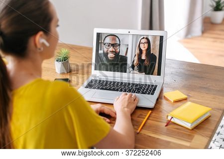Video Call Of Multiracial Team. A Young Woman Is Talking Online With Coworkers, Friends