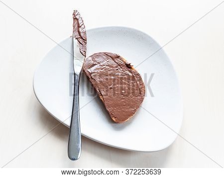 Top View Of Toast With Chocolatte Spread And Knife On Plate On Table