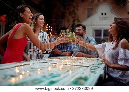 Group of young frinds making a toast at night party