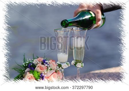 Hand Pouring Champagne Into Wedding Glasses