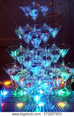 Martini Glasses In The Form Of A Cascade Or Pyramid Lit Light At The Wedding Party