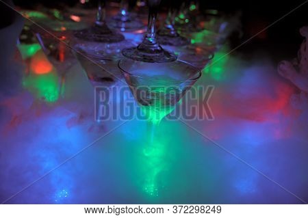 Glasses Of Champagne And Lights And Smoke From Dry Ice