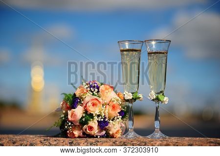 Two Glasses Of Champagne And A Beautiful Tender Festive Wedding Bouquet Of Flowers