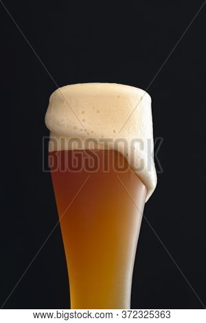 Cold White Beer In A Long Classic Glass With Foam. German Traditional Drink, The Yeast Beer. Glass O