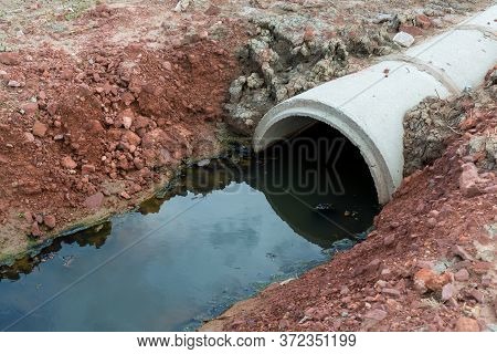 Concrete Circular Run-off Pipe Discharging Water. Sewage Pipe Polluting The River. Sewage Or Domesti