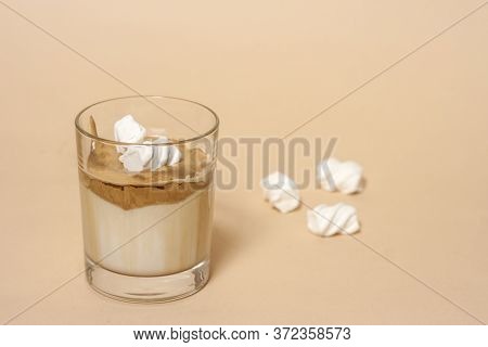 Dalgon Coffee In A Transparent Glass With Milk On A Pastel Background With Marshmallows.