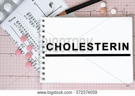 Notebook Page With Text Cholesterin On A Table With A Pills And Pencil, Medical Concept, Top View