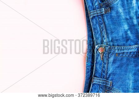Blue Denim Malvina Jeans On Pastel Pink Background Copy Space Top View Flat Lay. Fashion Background.