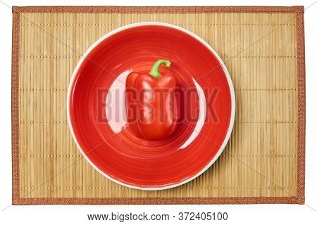 Color Still Life - Red Bell Pepper On A Red Plate On A Cane Serving Mat