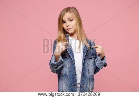 Confused Little Blonde Kid Girl 12-13 Years Old In Denim Jacket Isolated On Pastel Pink Background C