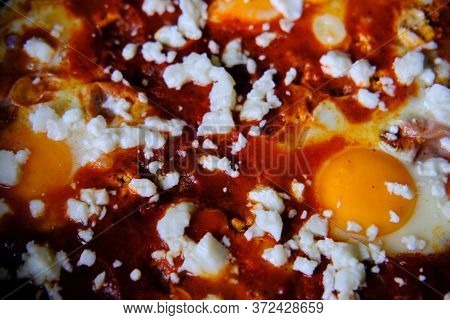 Shakshuka In A Frying Pan. Eggs Poached In Spicy Tomato Pepper Sauce