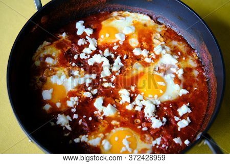 Shakshuka In A Frying Pan. Eggs Poached In Spicy Tomato Pepper Sauce