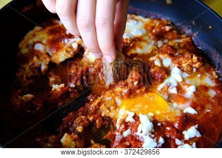 Shakshuka In A Frying Pan. Eggs Poached In Spicy Tomato Pepper Sauce