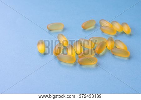 Soft Yellow Jelly Chewable Pills Filled By Fish Oil As A Source Of Omega 3. Capsules Are Lying On Bl