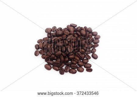 Many Roasted Coffee Beans Stacked On A White Background