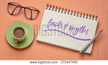 acts and myths note - handwriting in a spiral notebook with coffee and reading glasses, truth and fake news concept