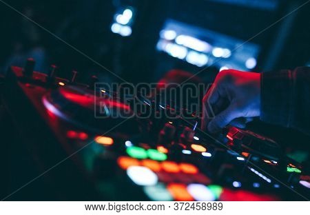 Producer  Dj Mixer In A Nightclub With Glowing Plays Musical Rave Dubstep Electronic Trance Composit